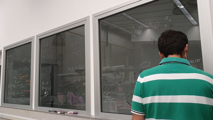 Imatge d'un estudiant de l'equip iGEM Barcelona fent càlculs pel seu projecte. 