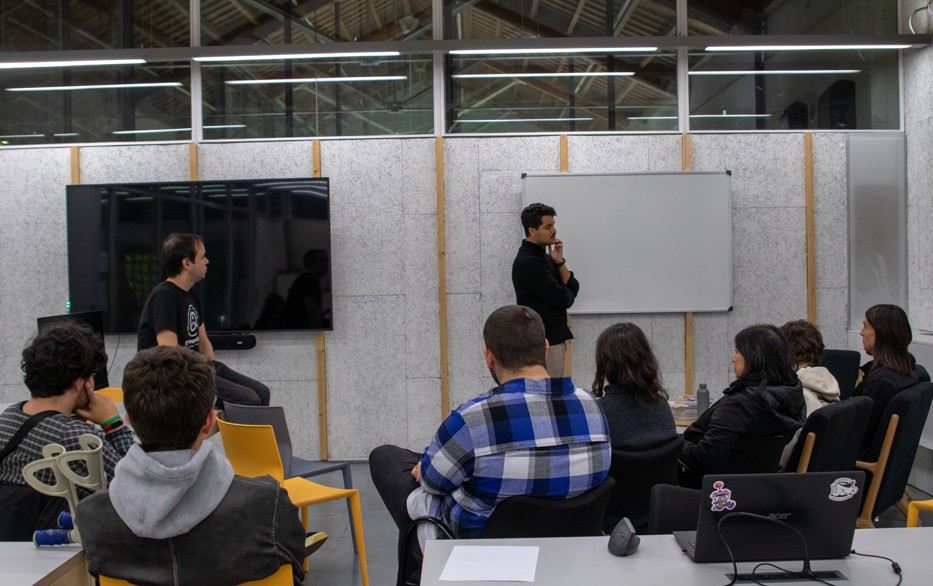 Alan Tapscott (davant a l’esquerra) i Christopher Vegas (davant a la dreta), del Departament de Comunicació de la UPF, dinamitzen el debat de la sessió del 3 de desembre de 2025 sobre llibertat d’acció i videojocs.